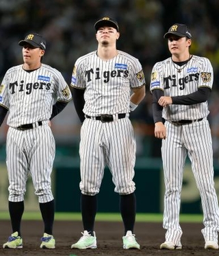 　今季最終戦を終え、セレモニーで整列するプロ野球阪神の佐藤輝明内野手（中央）。４年ぶり９人目の三冠王に輝いた＝８日、甲子園球場