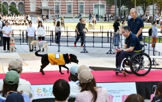 　「ともともフェスタ２０２６」で行われた、補助犬が障害者を手助けする様子のデモンストレーション＝９日午後、ＪＲ東京駅前