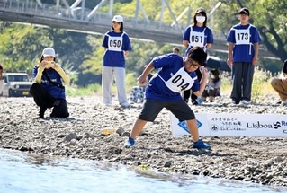 　「第２３回仁淀川国際水切り大会」で石を投げる参加者＝１１日午前、高知県いの町