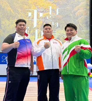 　現役最後の試合を終え、ポーズをとる重量挙げ男子の村上英士朗（右）＝１２日、青森県平川市（本人提供）