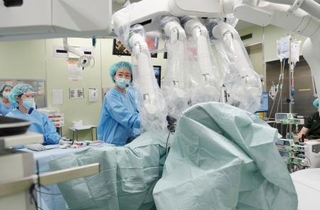 　ロボットを使った遠隔手術を補助する医師＝青森県弘前市の弘前大病院（同大提供）