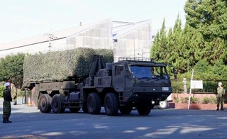 　陸自健軍駐屯地を出発する長射程ミサイルの車両＝１８日午前、熊本市