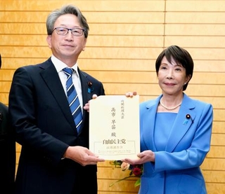 　自民党国家サイバーセキュリティ戦略本部の平将明本部長（左）から提言書を受け取る高市首相＝２３日午後、首相官邸