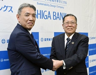 　４月、資本業務提携を発表し、握手する池田泉州ＨＤの阪口広一社長（左）と滋賀銀行の久保田真也頭取＝大阪市