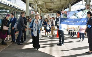 　豪華寝台列車「トワイライトエクスプレス瑞風」でＪＲ松江駅に到着し、歓迎を受ける日仏の作家ら＝２３日午前