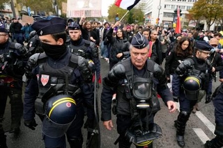 　２４日、デモ隊を警戒する警察官＝パリ（共同）