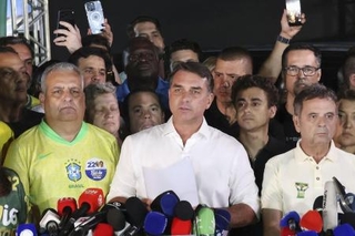 　ブラジル大統領選の結果を受け、記者団に話すフラビオ・ボルソナロ氏（中央）＝２５日、ブラジリア