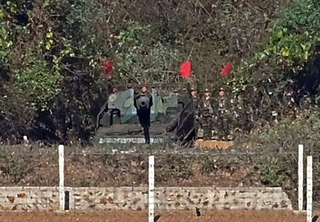 　２８日、韓国・京畿道金浦市の展望台で、対岸に見える北朝鮮の自走砲。そばには兵士らの姿もあった（共同）