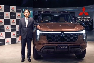 　三菱自動車が１２月に発売する新型「パジェロ」と岸浦恵介社長＝２９日午前、東京都港区