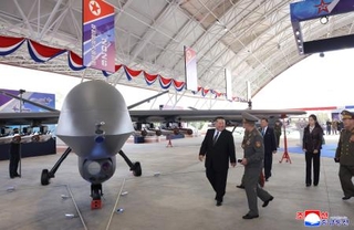 　無人機を視察する北朝鮮の金正恩朝鮮労働党総書記（左端）＝２９日（朝鮮中央通信＝共同）
