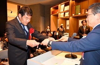 　「岩宿文化賞」の授賞式で、表彰状を受け取る奈良文化財研究所の国武貞克主任研究員（左）＝３１日午前、群馬県みどり市