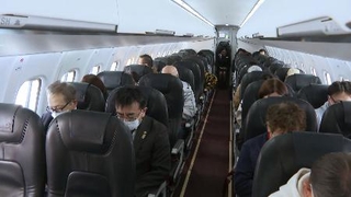 　北方領土周辺の上空を飛ぶ航空機内で黙とうをささげる元島民ら＝３１日午前（代表撮影）
