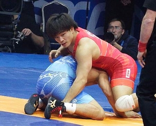　男子フリースタイル７４キロ級の準決勝で攻めをこらえる青柳善の輔＝アスタナ（共同）