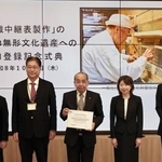　「伝統建築工匠の技」に「手織中継表製作」が追加登録され、認定書を手にする文化財畳技術保存会の磯垣昇理事長（中央）ら＝１日午後、京都市
