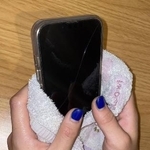 　手汗でスマートフォンが反応しづらくなるため、ハンドタオルを巻くようにして使う女性＝９月、東京都内