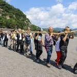 　三重県熊野市の花窟神社で営まれた「お綱かけ神事」でご神体の巨岩から大綱を引く参拝客ら＝２日午前