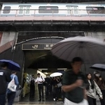 　傘を差して東京・新橋駅前を歩く人たち＝９月３０日