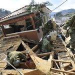 　東日本大震災で倒壊した家屋の内部を捜索する陸上自衛隊員ら＝２０１１年３月、宮城県女川町