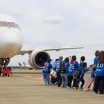 　ジェット機を綱で引っ張る児童や保護者ら＝４日午前、成田空港