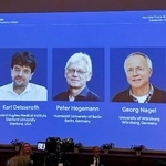 　ノーベル生理学・医学賞の受賞者発表記者会見でスクリーンに映し出された（左から）カール・ダイセロス教授、ペーター・ヘーゲマン教授、ゲオルク・ナーゲル教授＝５日、ストックホルム（共同）