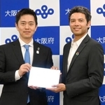 　締結式で撮影に応じる大阪府の吉村洋文知事（左）と米グーグルのマグワイア氏＝６日、大阪市
