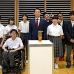 　アジアパラ大会聖火リレーの火がともされたランタンと写真に納まる生徒ら＝６日午後、愛知県西尾市