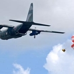 　６日、フィリピン中部タクロバンで、救援物資に見立てた箱を投下する航空自衛隊の輸送機（共同）