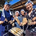 　石炭でサンマを焼く催しを企画した江尻浩二郎さん（左端）と住民の志賀喜美子さん（左から２人目）ら参加者＝８日午前、福島県いわき市