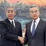 　中国の王毅外相（右）と握手する岩屋毅前外相＝９月、北京（新華社＝共同）