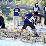 　「第２３回仁淀川国際水切り大会」で石を投げる参加者＝１１日午前、高知県いの町