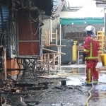 　全焼した市場「マルシェ・デ・ザンファン・ルージュ」で消火活動に当たる消防士＝１２日、パリ（共同）