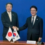 　水嶋光一駐韓国大使（左）と握手する韓国の革新系与党「共に民主党」の金民錫代表＝１５日、ソウル（共同）