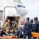 　旅客機の事故を想定し、機内から救出された負傷者を運ぶ訓練＝１５日午後、成田空港