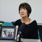 　提訴後、遺影を前に記者会見する男性の母親＝１５日午後、京都市