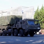 　陸自健軍駐屯地を出発する長射程ミサイルの車両＝１８日午前、熊本市