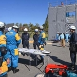 　建物の倒壊を想定した現場で訓練する警察官や消防隊員ら＝１８日午前、石川県小松市