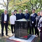 　顕彰碑の除幕式で写真に納まる参加者ら＝１８日午後、長崎市