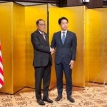 　会談前に握手するマレーシアのカレド国防相（左）と小泉防衛相＝１９日午後、東京都内