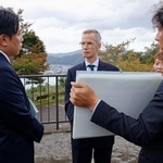　拉致現場付近で福井県警の担当者から説明を受けるジェローム・ライアン氏（左から２人目）＝２２日午前、福井県小浜市