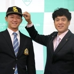 　城島ＣＢＯ（右）から帽子をかぶせてもらうソフトバンク１位指名の青学大・鈴木泰成投手＝２３日、東京都