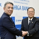 　４月、資本業務提携を発表し、握手する池田泉州ＨＤの阪口広一社長（左）と滋賀銀行の久保田真也頭取＝大阪市