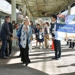 　豪華寝台列車「トワイライトエクスプレス瑞風」でＪＲ松江駅に到着し、歓迎を受ける日仏の作家ら＝２３日午前