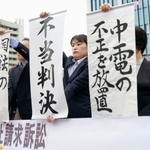 　浜岡原発運転差し止め訴訟の判決を受け、「不当判決」などと書かれた紙を掲げる弁護士ら＝２７日午後、静岡地裁前