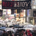 　２０２５年１０月のハロウィーンで、雨が降る東京・渋谷を歩く人たち