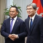 　カンボジアのソー・テット国家警察長官（左）と握手する警察庁の楠芳伸長官＝２８日午後、東京都内