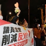 　国会議員会館前で開かれた抗議集会で、衆院議員定数削減法案に反対する人たち＝２８日夜
