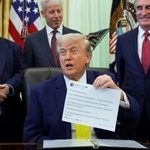 　「トゥルース・ソーシャル」への投稿を印刷した紙を掲げるトランプ米大統領＝６月、ワシントンのホワイトハウス（ロイター＝共同）