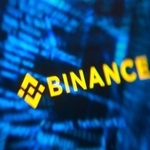 　バイナンスのロゴとハッカーのコードのイメージ（ロイター＝共同）