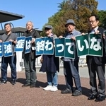 　カネカの高砂工場前でメッセージを掲げる「カネミ油症」の被害者ら＝３１日午前、兵庫県高砂市