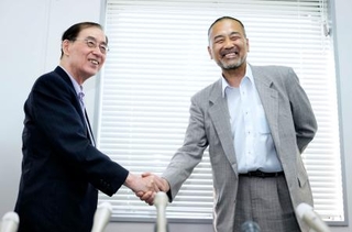 　福井中３殺害事件の再審無罪が確定し、記者会見後に吉村悟弁護団長（左）と握手する前川彰司さん＝１日午後、福井市